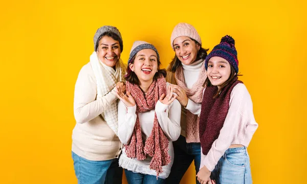 メキシコの黄色の背景に幸せなラテン語の家族の3世代のヒスパニック女性の冬の肖像ラテンアメリカ — ストック写真