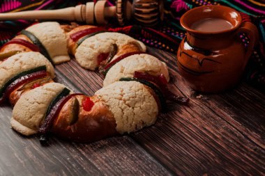 Rosca de Reyes ya da Epiphany keki ve Meksika Latin Amerika 'da tahta masada bir fincan Meksika sıcak çikolatası.