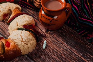 Rosca de Reyes ya da Epiphany keki ve Meksika Latin Amerika 'da tahta masada bir fincan Meksika sıcak çikolatası.