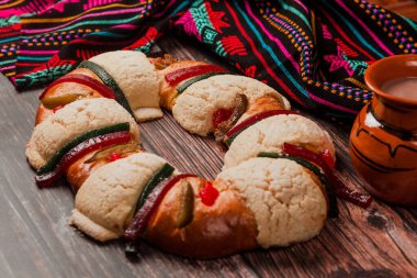 Rosca de Reyes ya da Epiphany keki ve Meksika Latin Amerika 'da tahta masada bir fincan Meksika sıcak çikolatası.