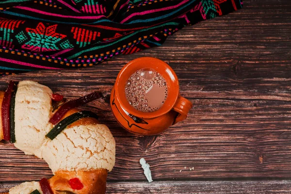Rosca de Reyes ya da Epiphany keki ve Meksika Latin Amerika 'da tahta masada bir fincan Meksika sıcak çikolatası.