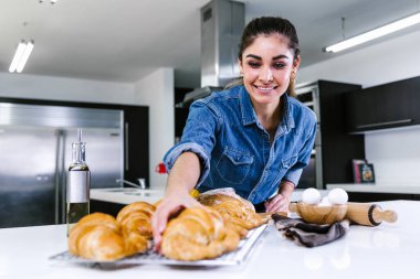 Latin Amerika 'da mutfakta kruvasan pişiren genç Latin bir kadın.