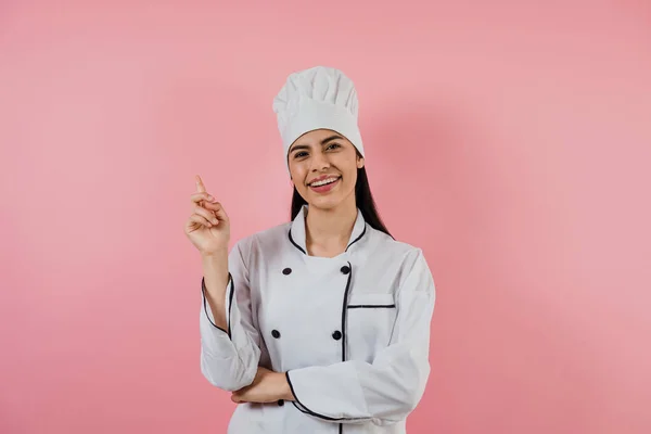 Portrait of young latin woman chef on a pink background in latin america