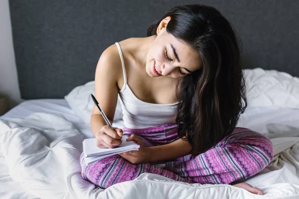 Lateinisches Junges Mädchen Mit Computer Und Notizbuch Auf Dem Bett — Stockfoto