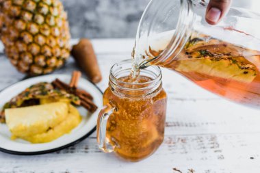 Tepache Meksika Fermente edilmiş ananas içeceği ve elinde kombucha ev yapımı probiyotik süper yiyecek olan bir kavanoz Mexico City 'de dilimlenmiş ananas içeceği.