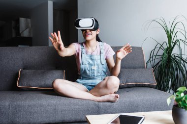 Latin Amerikalı genç bir kadın Meksika 'da sanal gerçeklik gözlüğü kullanıyor ve oynuyor.