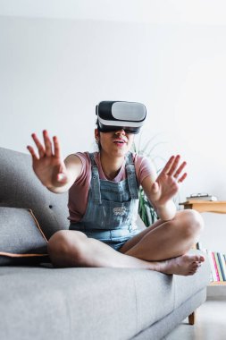 Latin Amerikalı genç bir kadın Meksika 'da sanal gerçeklik gözlüğü kullanıyor ve oynuyor.