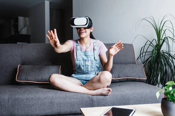 Latin Amerikalı genç bir kadın Meksika 'da sanal gerçeklik gözlüğü kullanıyor ve oynuyor.