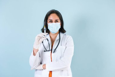 Latin kadın doktor elinde koronavirüs aşısı tutuyordu. Meksika Latin Amerika 'da maske takıyordu. 