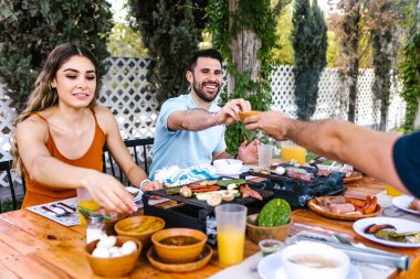 Latin Amerika 'nın Meksika restoranının terasında geleneksel Meksika yemeklerini yiyen bir grup Latin arkadaş.