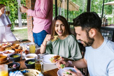 Latin Amerika 'nın Meksika restoranının terasında geleneksel Meksika yemeklerini yiyen bir grup Latin arkadaş.