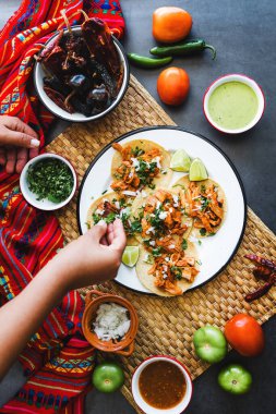 Meksikalı kadın Meksika 'da soslu taco hazırlıyor.