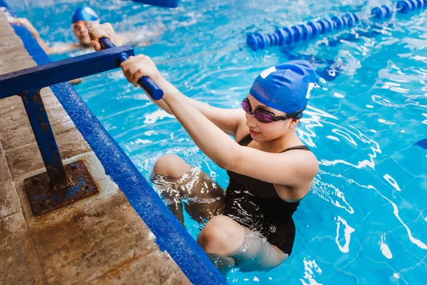 在墨西哥拉美地区 一名身穿泳帽和护目镜的少女选手参加了在泳池起跳区举行的游泳训练 — 图库照片