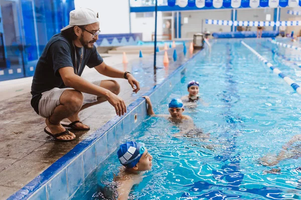 在墨西哥 一名拉丁游泳教练在游泳池边给学生们提一些建议 — 图库照片