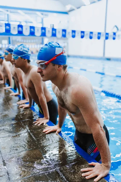 latin young man swimmer athlete wearing cap and goggles in a swimming training in the Pool in Mexico Latin America