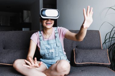 Latin Amerika 'da oynayan ve sanal gerçeklik gözlüğü kullanan genç İspanyol kadın.