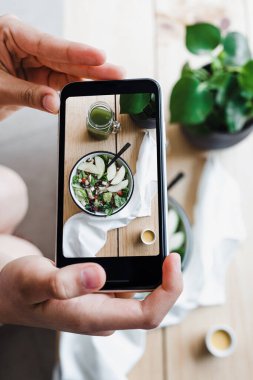 Salata kasesi ve ahşap masada yeşil meyve suyu cep telefonlu fotoğraf, Meksika 'da sağlıklı yiyecekler.
