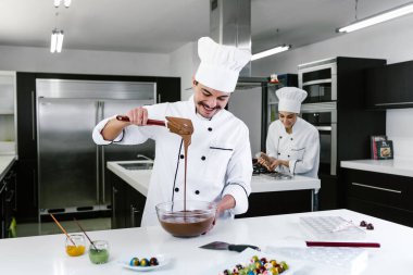 Latin adam pasta şefi üniforma giyiyor ve Meksika Latin Amerika 'da mutfakta lezzetli çikolatalar hazırlıyor.
