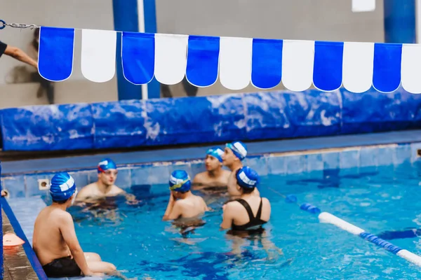 public swimming pool with team of people in competition or training at background in Latin America