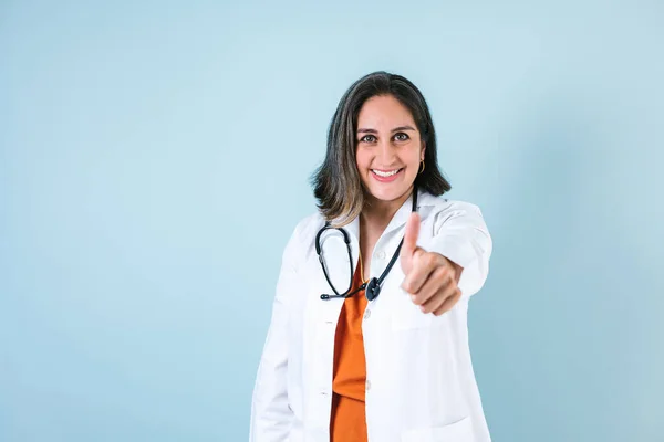 在墨西哥 拉丁裔医生女人的大拇指在蓝色的背景下翘起 — 图库照片
