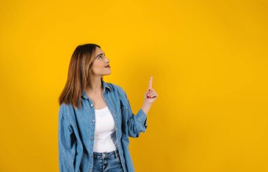 Latin Amerika 'da sarı arka planda fotokopi alanı olan esmer, genç bir İspanyol kadının portresi.