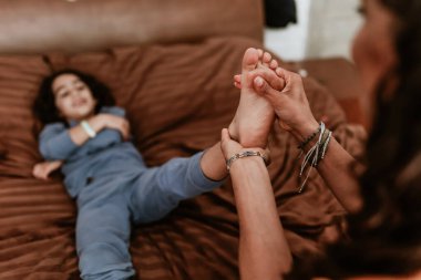 İspanyol anne oğluna krem, merhem ya da merhem sürüyor. Meksika 'da, Latin Amerika' da yatakta.