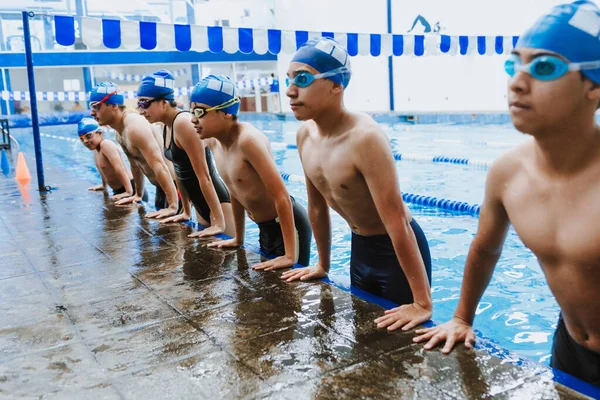latin young man swimmer athlete wearing cap and goggles in a swimming training in the Pool in Mexico Latin America