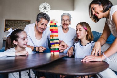 Latin Amerika 'da üç nesil boyunca Latin Amerika' da büyükannesi ve kızıyla Jenga oynayan İspanyol bir aile.