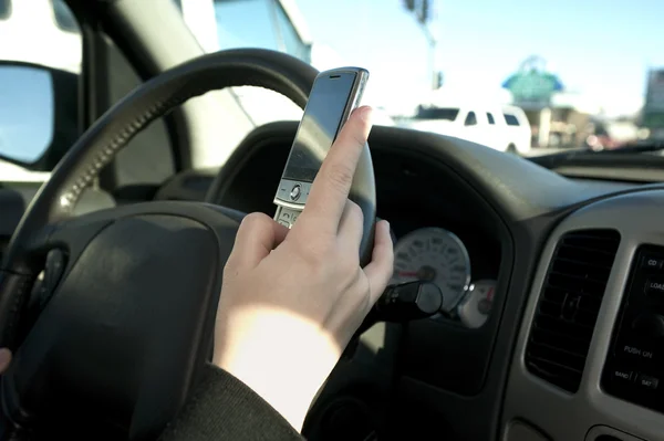 Hand av en tonåring textning under körning — Stockfoto