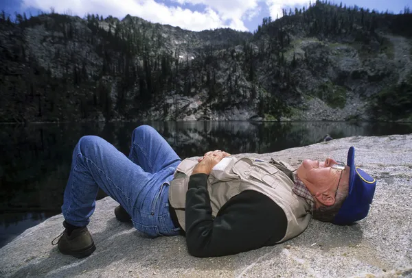 Active senior man napping on a rock — Stock Photo, Image