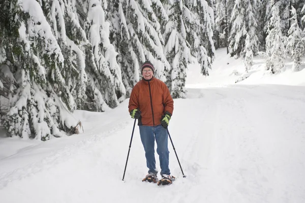 Senior man snowshoeing — Stock Photo, Image