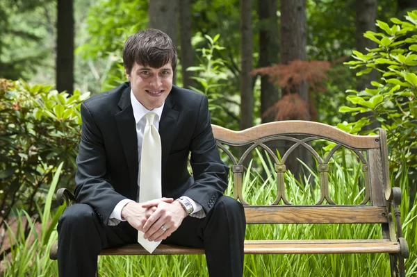 Wedding groom sitting on bench — Stock Photo, Image