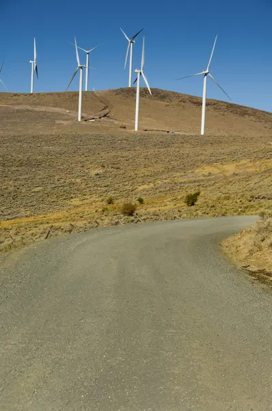 Rüzgâr türbinleri arasında çakıl yol. — Stok fotoğraf