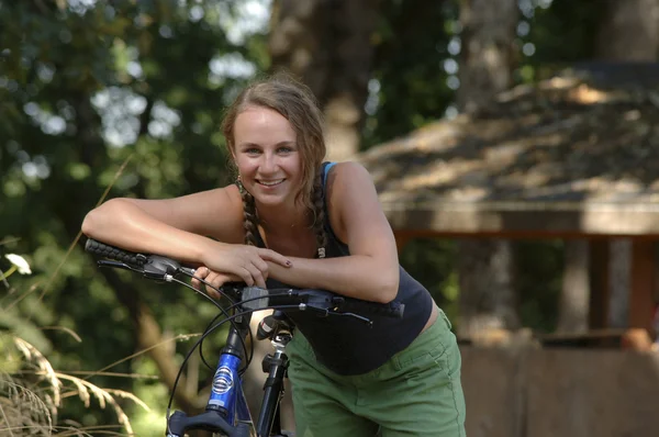 Teen girl resting on handlebars of bicycle — Stock Photo, Image