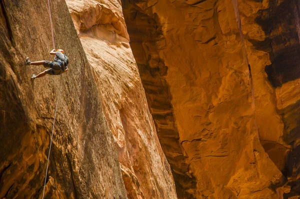 砂漠に崖を懸垂下降の男 — ストック写真