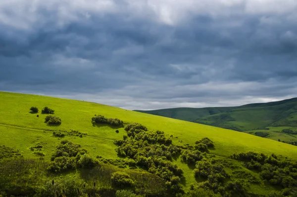 Paesaggio di colline con nuvole scure — Foto Stock