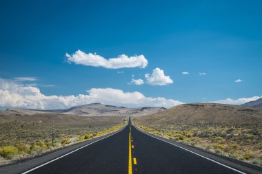 Blue sky and clouds above desert highway clipart