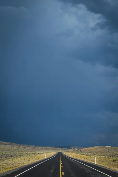 Nuvens de tempestade escuras acima da estrada do deserto — Fotografia de Stock