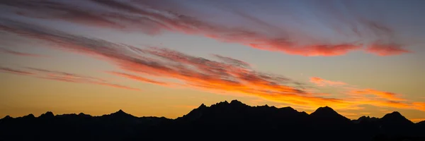 Sunrise clouds and mountain silhouettes — Stock Photo, Image