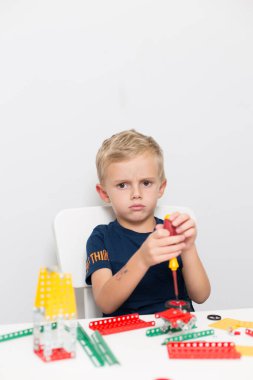 Metal inşaat setinde küçük bir çocuk oynanıyor. Beş yıl.