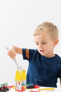 Metal inşaat setinde küçük bir çocuk oynanıyor. Beş yıl.