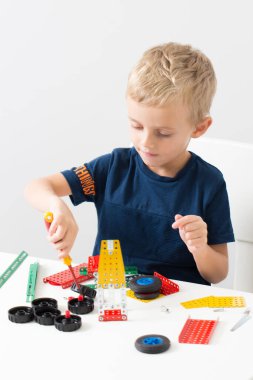 Metal inşaat setinde küçük bir çocuk oynanıyor. Beş yıl.