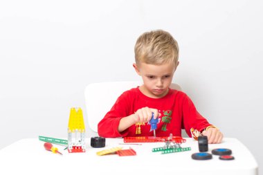 Metal inşaat setinde küçük bir çocuk oynanıyor. Beş yıl.