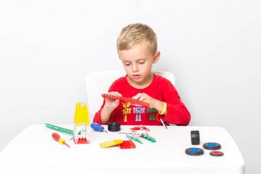 Metal inşaat setinde küçük bir çocuk oynanıyor. Beş yıl.