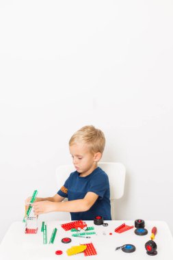 Metal inşaat setinde küçük bir çocuk oynanıyor. Beş yıl.