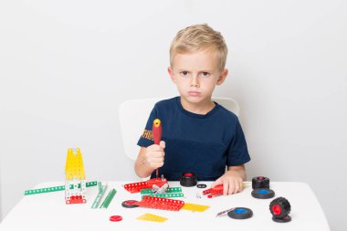 Metal inşaat setinde küçük bir çocuk oynanıyor. Beş yıl.