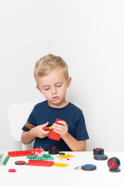 Metal inşaat setinde küçük bir çocuk oynanıyor. Beş yıl.