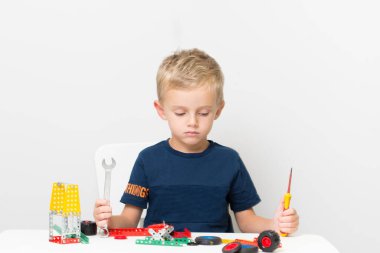 Metal inşaat setinde küçük bir çocuk oynanıyor. Beş yıl.