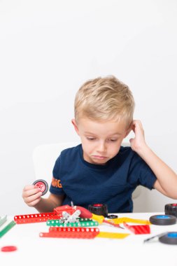 Metal inşaat setinde küçük bir çocuk oynanıyor. Beş yıl.