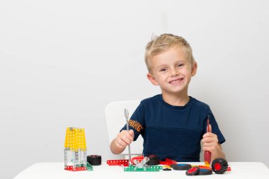 Metal inşaat setinde küçük bir çocuk oynanıyor. Beş yıl.